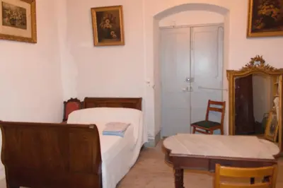 a bedroom with two beds and a table and a mirror at Appartement Vezzani Centre Corse in Vezzani