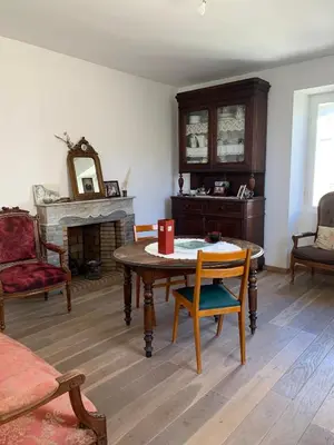 a living room with a table and a fireplace at Appartement Vezzani Centre Corse in Vezzani