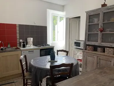a kitchen with a table and chairs in a kitchen at Appartement Vezzani Centre Corse in Vezzani