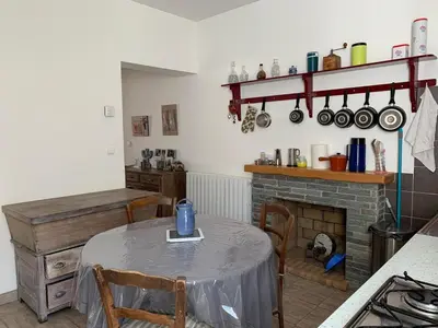 a living room with a table and a fireplace at Appartement Vezzani Centre Corse in Vezzani
