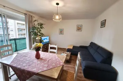 a living room with a blue couch and a table at Charming T3 with balconies in Ajaccio in Ajaccio