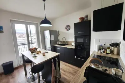 a kitchen with a table and a kitchen with black cabinets at Charming T3 with balconies in Ajaccio in Ajaccio