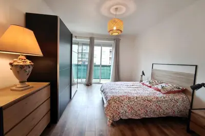 a bedroom with a bed and a lamp and a window at Charming T3 with balconies in Ajaccio in Ajaccio