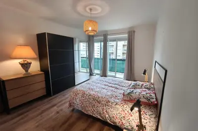 a bedroom with a bed and a large window at Charming T3 with balconies in Ajaccio in Ajaccio
