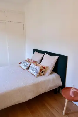 a bedroom with a bed with pillows and a table at Magnifique T3 de 85m2 de standing vue mer trottel in Ajaccio