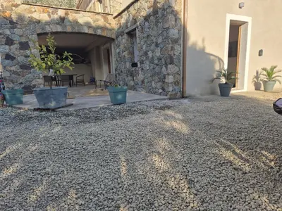 a stone building with potted plants and a patio at CasaKia in Pietralba