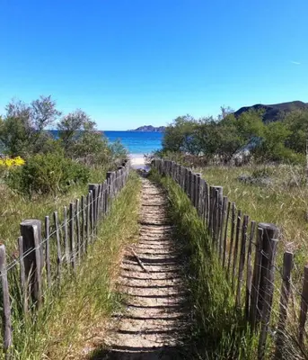 a dirt road leading to a beach next to a fence at CasaKia in Pietralba