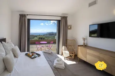 a hotel room with a bed and a large window at Villa d’exception 4 chambres, piscine, vue mer in Porto-Vecchio