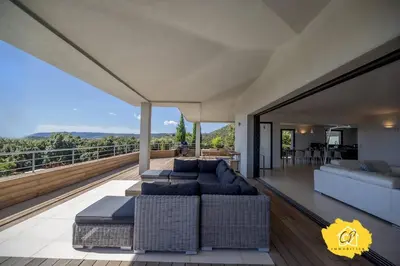a living room with two couches and a balcony at Villa d’exception 4 chambres, piscine, vue mer in Porto-Vecchio