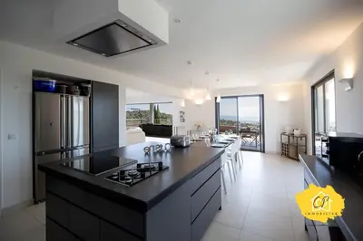 a kitchen with a black counter top in a room at Villa d’exception 4 chambres, piscine, vue mer in Porto-Vecchio