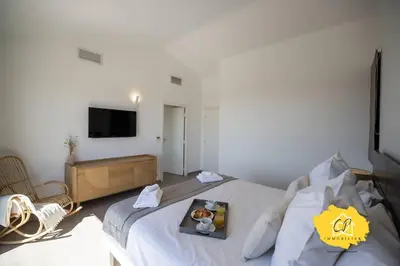 a bedroom with a bed with a tray of food on it at Villa d’exception 4 chambres, piscine, vue mer in Porto-Vecchio