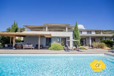 a house with a swimming pool in front of it at Villa d’exception 4 chambres, piscine, vue mer in Porto-Vecchio