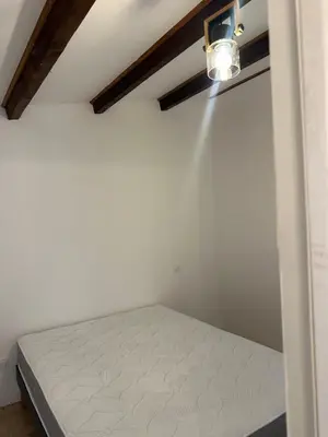 a bed in a room with a light on the wall at Charming village house in Cambia