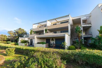 an apartment building with balconies and a yard at Clos Vignola - Domaine de la Viva -Superbe vue mer in Grosseto-Prugna