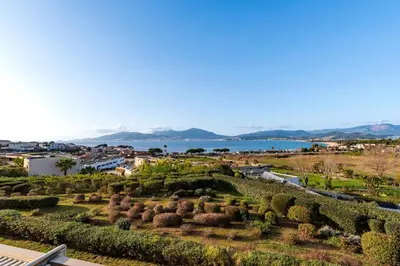 a garden with a view of the water and mountains at Clos Vignola - Domaine de la Viva -Superbe vue mer in Grosseto-Prugna