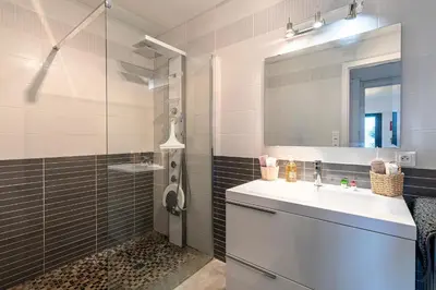 a bathroom with a sink and a shower with a mirror at Clos Vignola - Domaine de la Viva -Superbe vue mer in Grosseto-Prugna