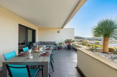 a table and chairs on the balcony of a house at Clos Vignola - Domaine de la Viva -Superbe vue mer in Grosseto-Prugna