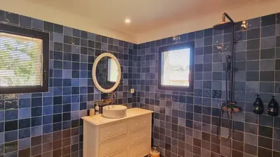 a blue tiled bathroom with a sink and a mirror at Domaine de Gialla Bergerie Figa, 2 pers, piscine chauffée, 10 mn plage in Arraggio