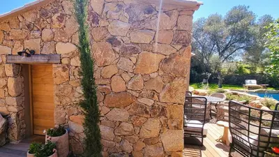 a stone wall with a patio and a pool at Domaine de Gialla Bergerie Figa, 2 pers, piscine chauffée, 10 mn plage in Arraggio