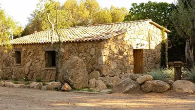a stone house with rocks in front of it at Domaine de Gialla Bergerie Figa, 2 pers, piscine chauffée, 10 mn plage in Arraggio