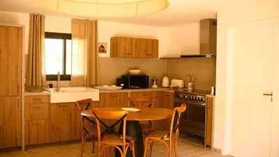 a kitchen with a wooden table and chairs in a kitchen at Domaine de Gialla Bergerie Figa, 2 pers, piscine chauffée, 10 mn plage in Arraggio