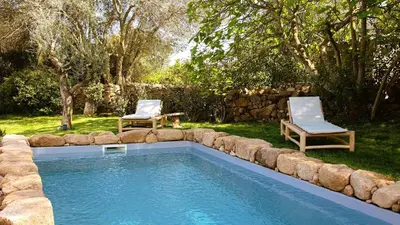 a swimming pool with two chairs and a table at Domaine de Gialla Bergerie Figa, 2 pers, piscine chauffée, 10 mn plage in Arraggio
