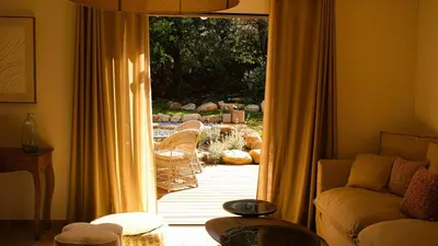 a living room with a door open to a patio at Domaine de Gialla Bergerie Figa, 2 pers, piscine chauffée, 10 mn plage in Arraggio