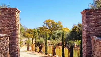 an entrance to a garden with a fence and trees at Domaine de Gialla Bergerie Quercia, 2 pers, piscine chauffée, 10 mn plage in Arraggio