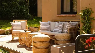 a patio with wicker chairs and pillows and tables at Domaine de Gialla Bergerie Figa, 4 pers, piscine chauffée, 10 mn plage in Arraggio