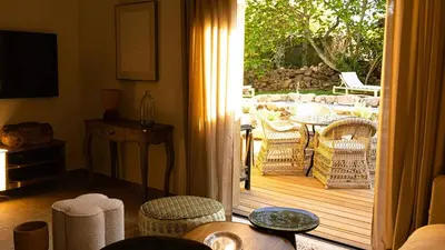 a living room with a door open to a patio at Domaine de Gialla Bergerie Figa, 4 pers, piscine chauffée, 10 mn plage in Arraggio