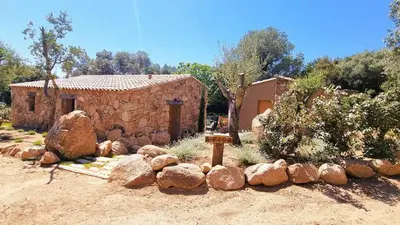 a small stone house with a building in a yard at Domaine de Gialla Bergerie Figa, 4 pers, piscine chauffée, 10 mn plage in Arraggio