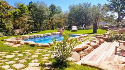 a swimming pool in a yard with rocks around it at Domaine de Gialla Bergerie Quercia, 4 pers, piscine chauffée, 10 mn plage in Arraggio
