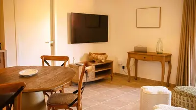 a living room with a table and a television at Domaine de Gialla Bergerie Quercia, 4 pers, piscine chauffée, 10 mn plage in Arraggio