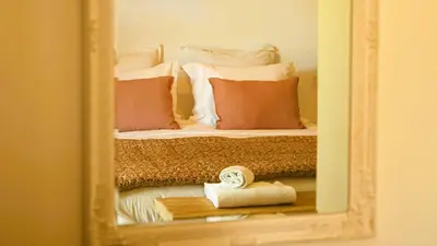 a reflection of a bed with pillows in a mirror at Domaine de Gialla Bergerie Quercia, 4 pers, piscine chauffée, 10 mn plage in Arraggio