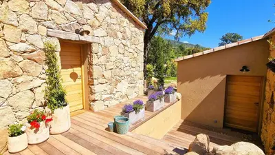 a wooden deck with potted plants and a building at Domaine de Gialla Bergerie Quercia, 4 pers, piscine chauffée, 10 mn plage in Arraggio