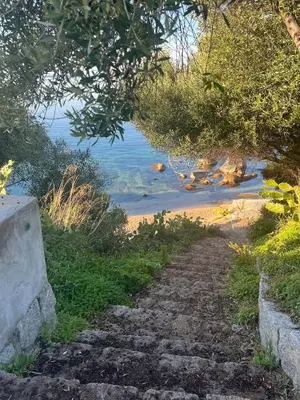 a stone path leading to a beach with the ocean at Luxury residence apartment with sea view, parking in Ajaccio