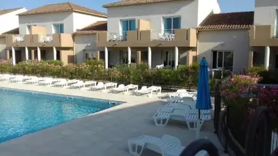 a view of a resort with a pool and flowers at Appartement 3 étoiles - Piscine - ccaiibh in Linguizzetta