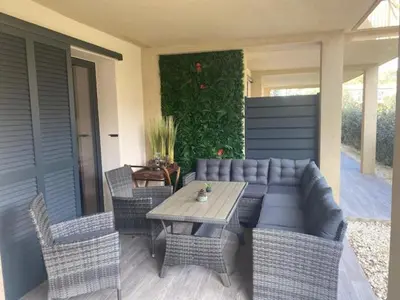 a patio with a table and wicker chairs at villa jérémy in Bonifacio