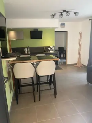 a kitchen with a table and two white chairs at villa jérémy in Bonifacio