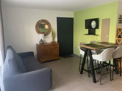 a living room with a blue couch and a table at villa jérémy in Bonifacio