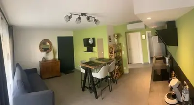 a living room with a table and a blue couch at villa jérémy in Bonifacio