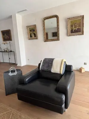 a black leather chair in a living room with a mirror at casa di santa in Aléria