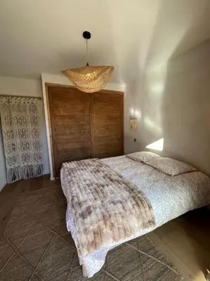 a bedroom with a bed and a chandelier at casa di santa in Aléria
