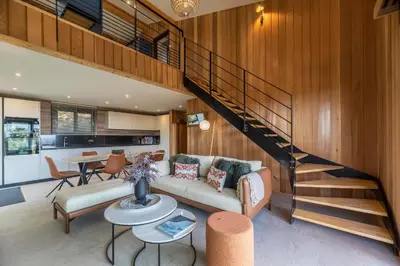 a living room with a couch and a staircase at Chalet U Picculu Di Arasu in Sainte-Lucie de Porto-Vecchio