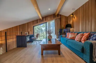 a living room with a blue couch and a table at Chalet U Picculu Di Arasu in Sainte-Lucie de Porto-Vecchio