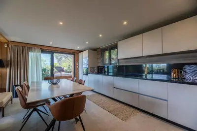 a kitchen with a wooden table and a dining room at Chalet U Picculu Di Arasu in Sainte-Lucie de Porto-Vecchio