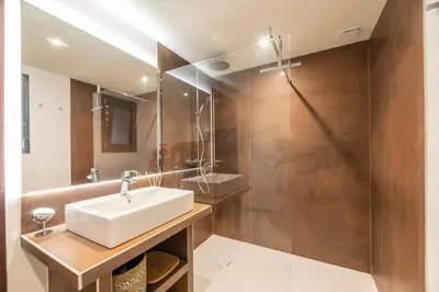 a bathroom with a white sink and a shower at Chalet U Picculu Di Arasu in Sainte-Lucie de Porto-Vecchio