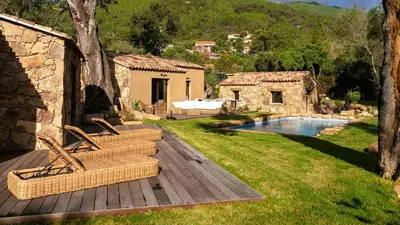 a patio with two wicker chairs and a swimming pool at Domaine de Gialla Bergerie I Pini, 8 pers, piscine chauffée, 10 mn plage in Arraggio