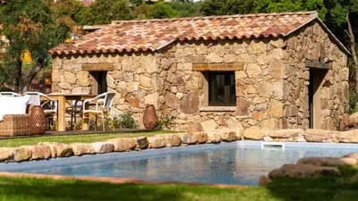 a stone building next to a swimming pool at Domaine de Gialla Bergerie I Pini, 8 pers, piscine chauffée, 10 mn plage in Arraggio