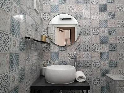a bathroom with a white sink and a mirror at Maisonette les pieds dans l'eau in Pietrosella